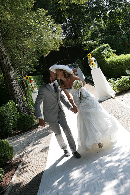 sposi mano nella mano si baciano in giardino