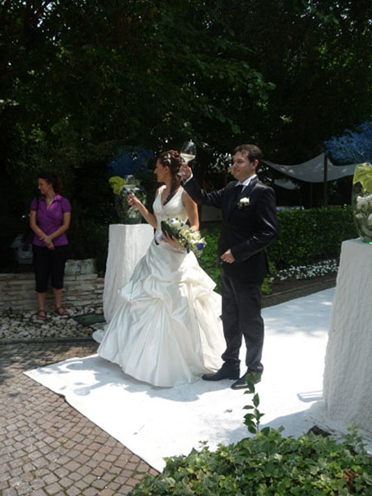 sposa e sposo brindano sul tappeto bianco in corti